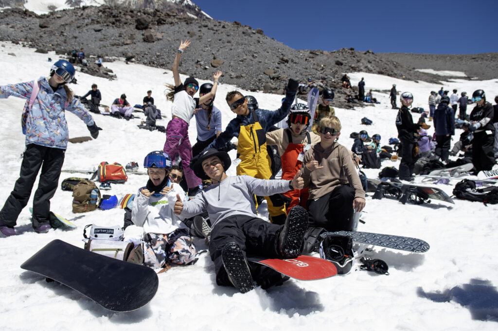 Chase Blackwell throws double thumbs up with his campers gathered around on the snow.